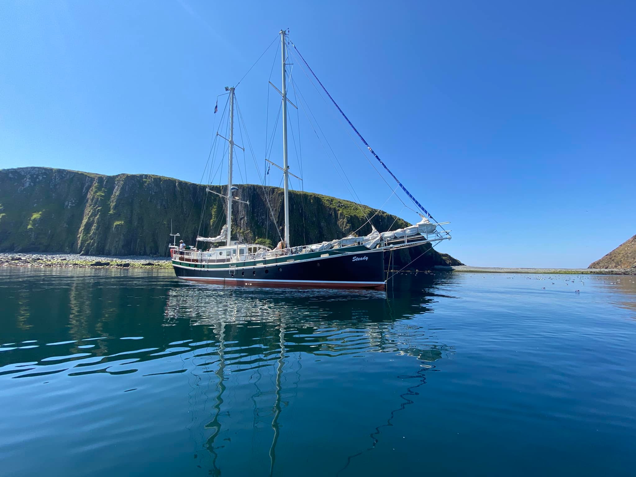 Zeilschip Steady Sailing voor anker bij een eiland in de Schotse Hebriden tijdens een zeilreis